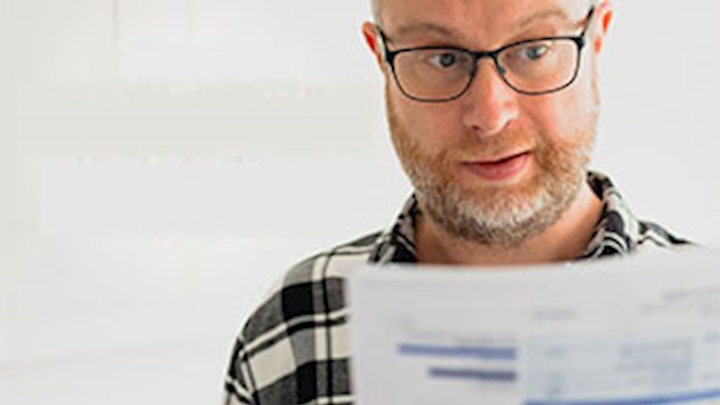 man in glasses looking surprised at high power bill